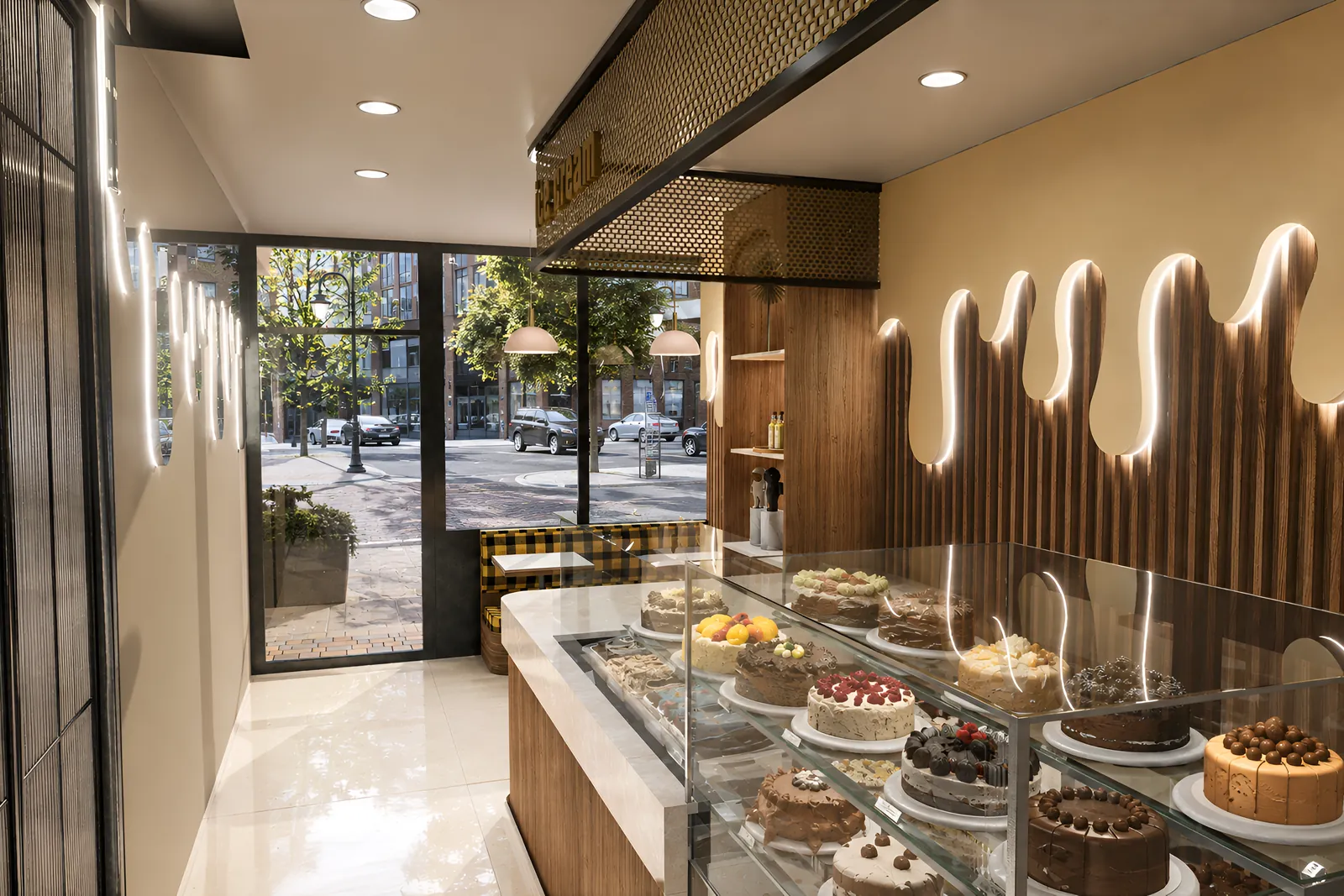 The bakery looking out to the street: the neon-traced drip wall over fluted walnut, cake display counter, and the brass mesh signage bulkhead overhead