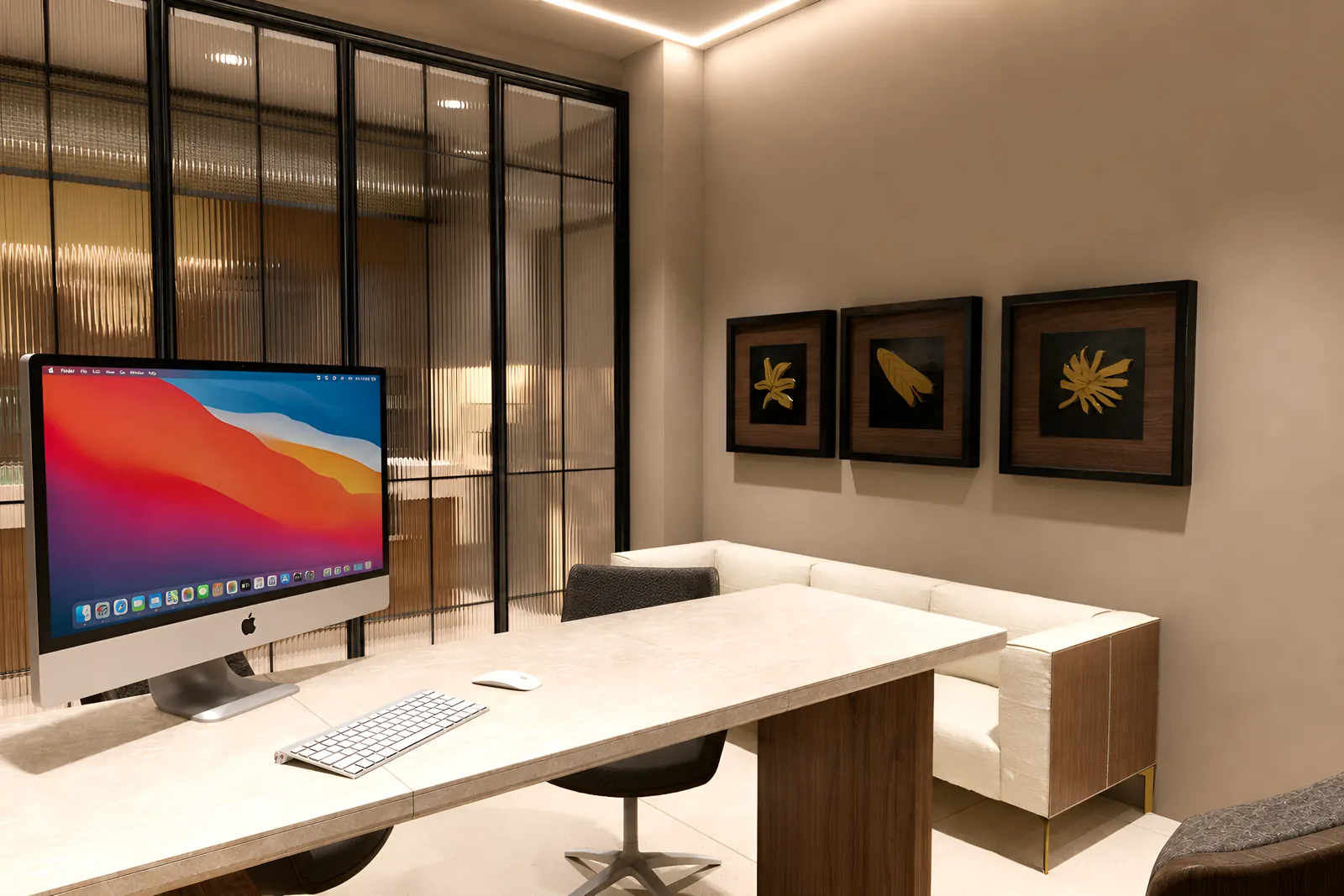 The office desk in travertine and walnut, against the reeded glass partition